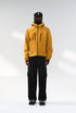 Yellow windbreaker jacket front view on model, hooded and relaxed fit