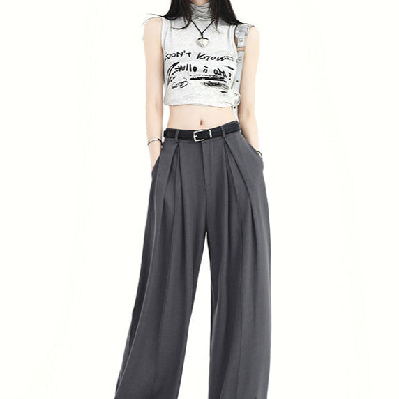 Woman wearing gray high waist pleated wide-leg pants with belt.