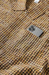 Yellow plaid shirt chest pocket with phone, fabric texture close