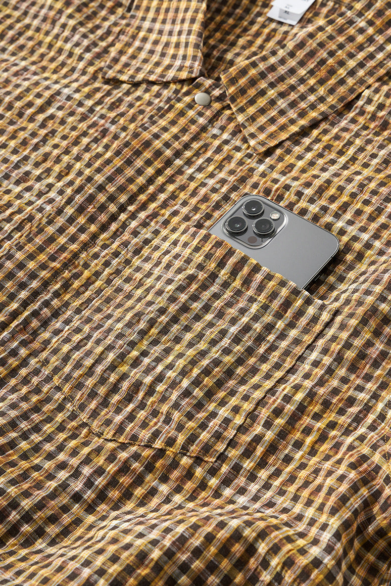 Yellow plaid shirt chest pocket with phone, fabric texture close