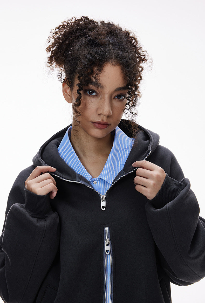 Person wearing a navy blue zip hoodie with a white background