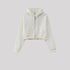 White cropped zip hoodie with front pocket on gray background. Features silver zipper and ribbed details