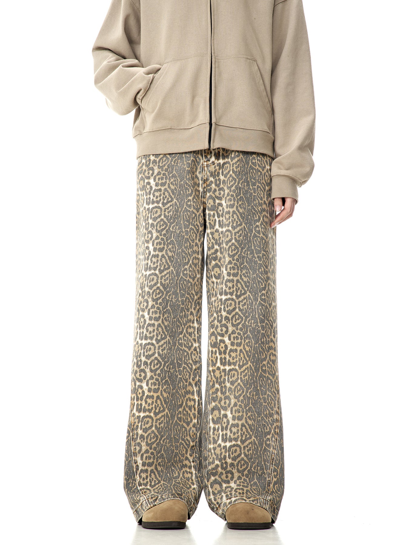 A model wearing beige zip-up hoodie and leopard print wide-leg pants standing against white background, showing full-length outfit view