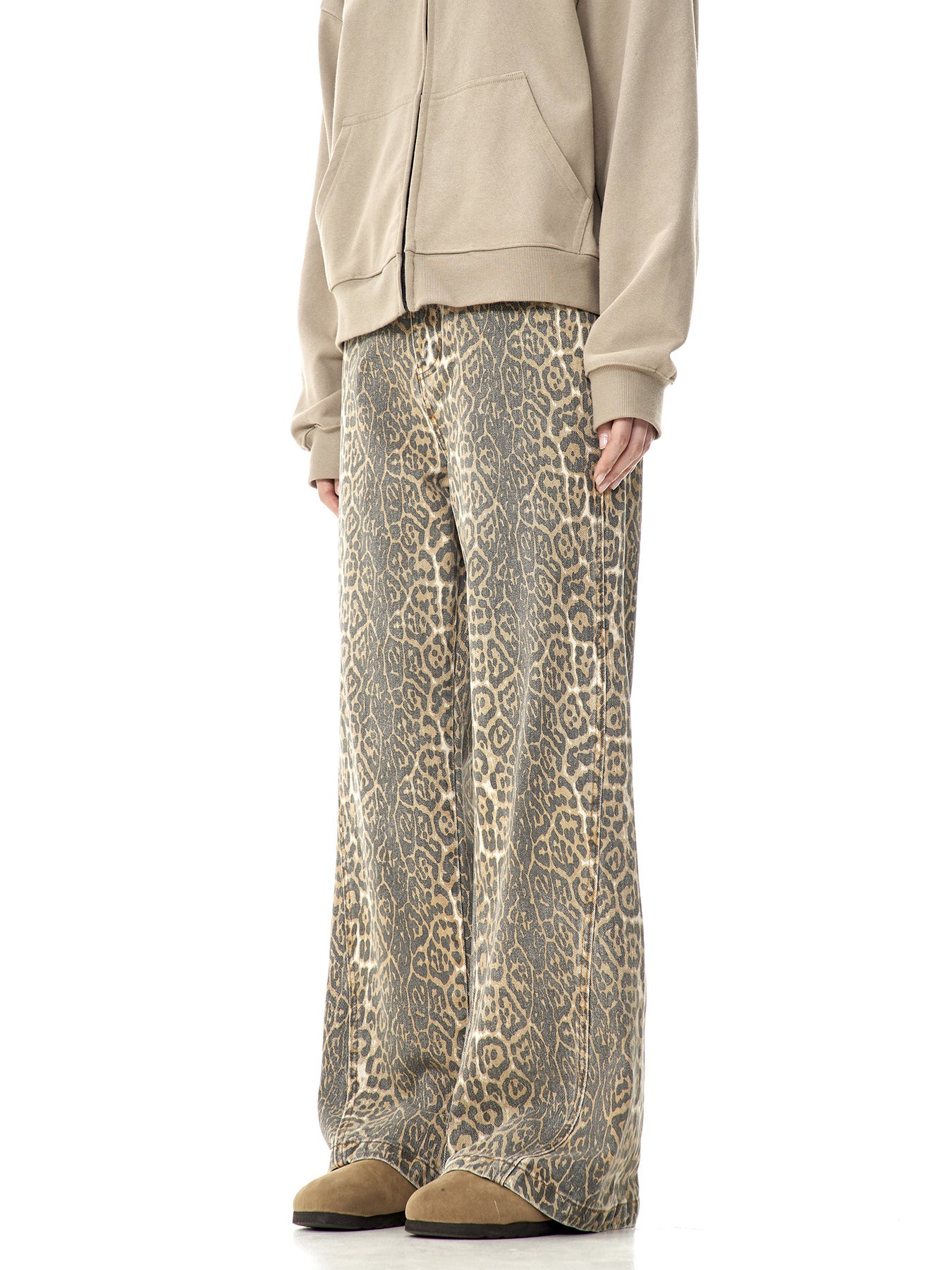 A model wearing beige zip-up hoodie and leopard print wide-leg pants viewed from side angle, showing relaxed silhouette against white background