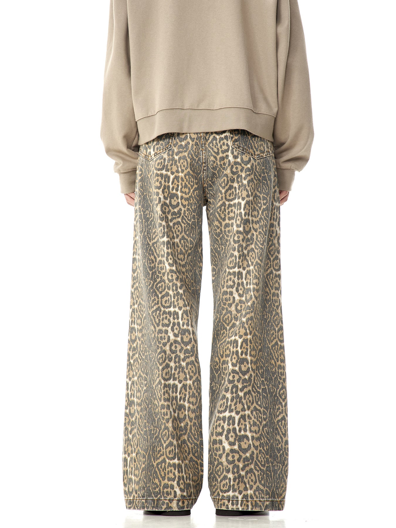 Rear view of leopard print wide-leg pants paired with beige sweatshirt, showing back pocket detail against white background