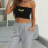 Black tube top with embroidered sunflowers paired with grey sweatpants