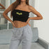 Black tube top with embroidered sunflowers paired with grey sweatpants