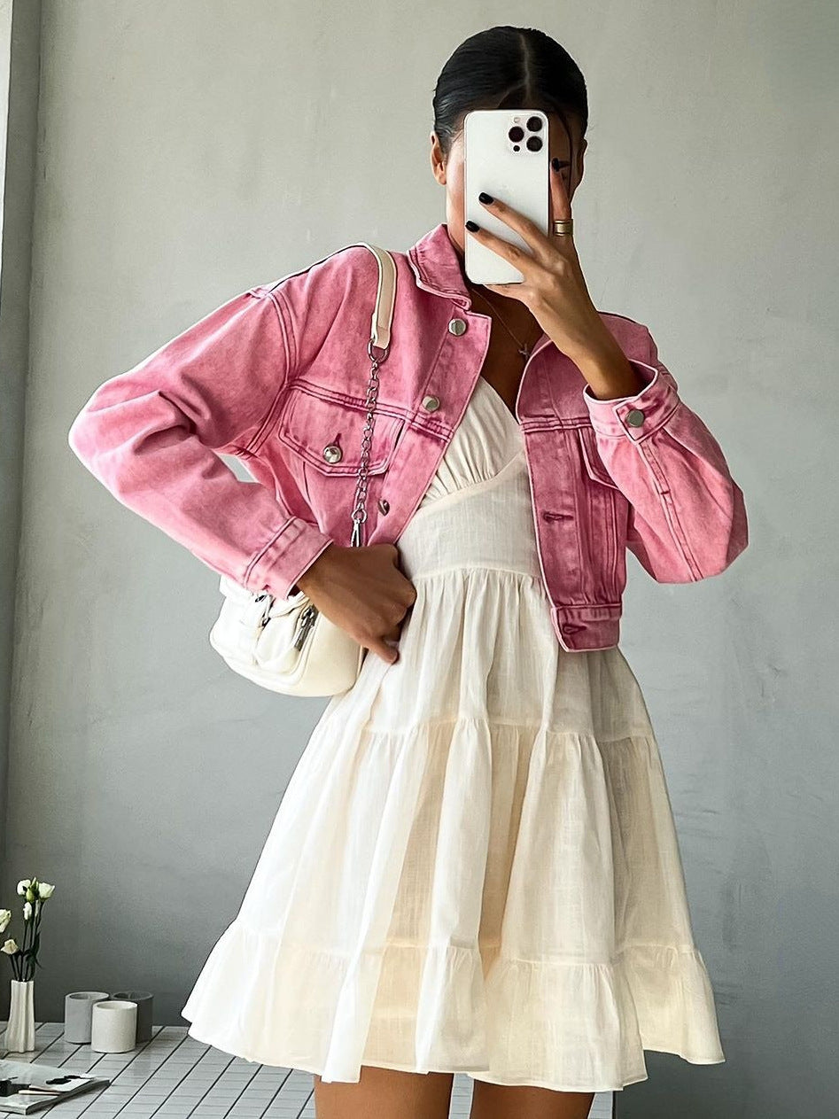 White spaghetti strap sundress with tiered skirt, layered with pink denim jacket and styled with chic smartphone and floral accessories
