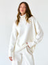 Cozy white oversized turtleneck sweater on hanger, soft ribbed texture, minimalist studio background