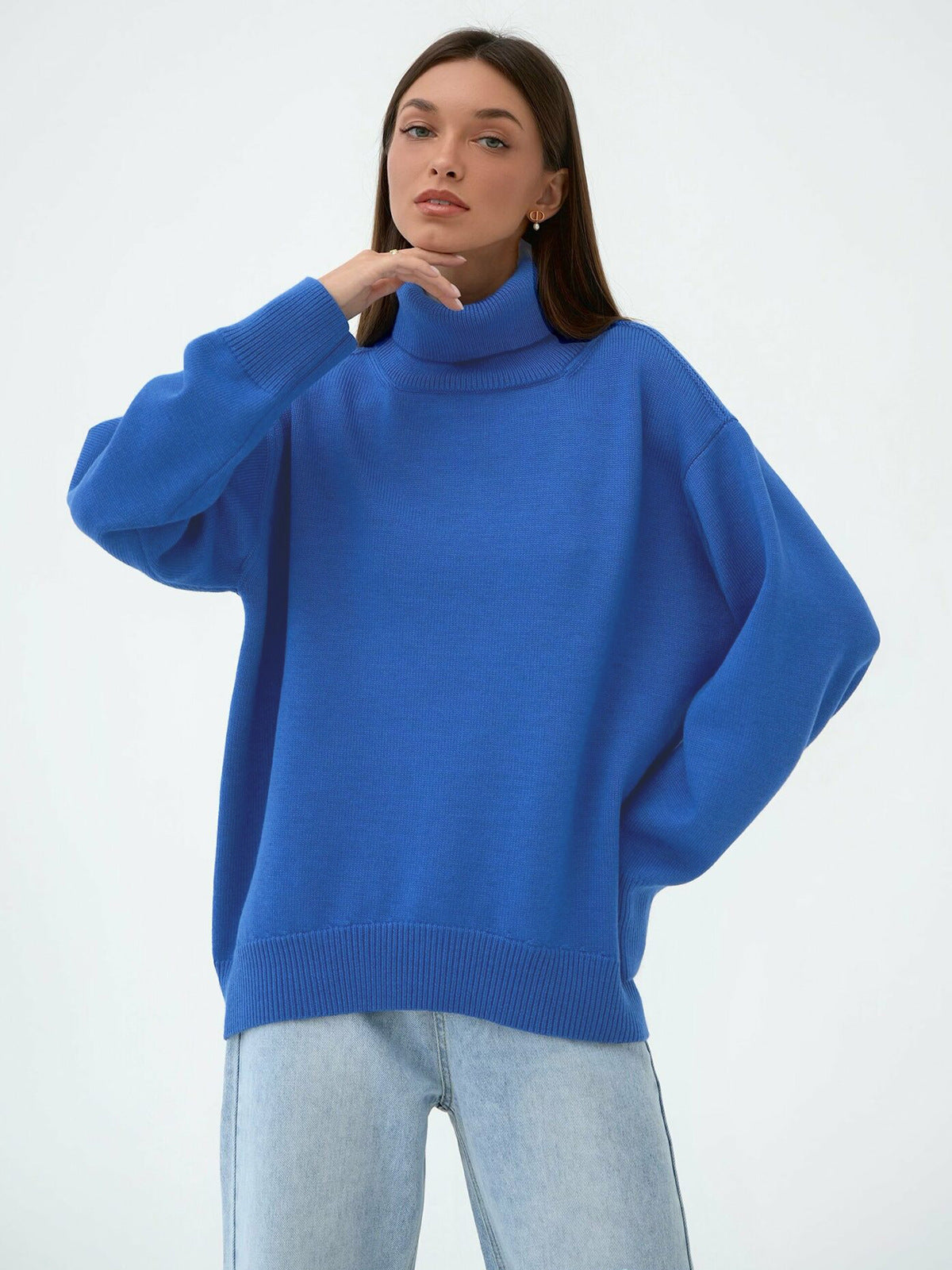 Model in relaxed blue turtleneck sweater, dropped shoulders, paired with light wash jeans