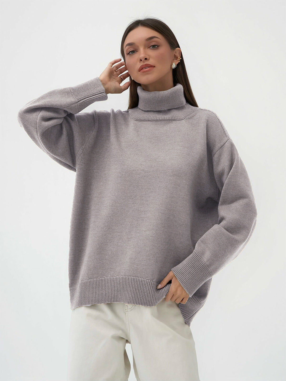 Light gray oversized turtleneck sweater hanging, ribbed details, clean minimalist setting