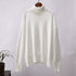 Crisp white knit turtleneck on wooden hanger, ribbed collar, houseplant in background
