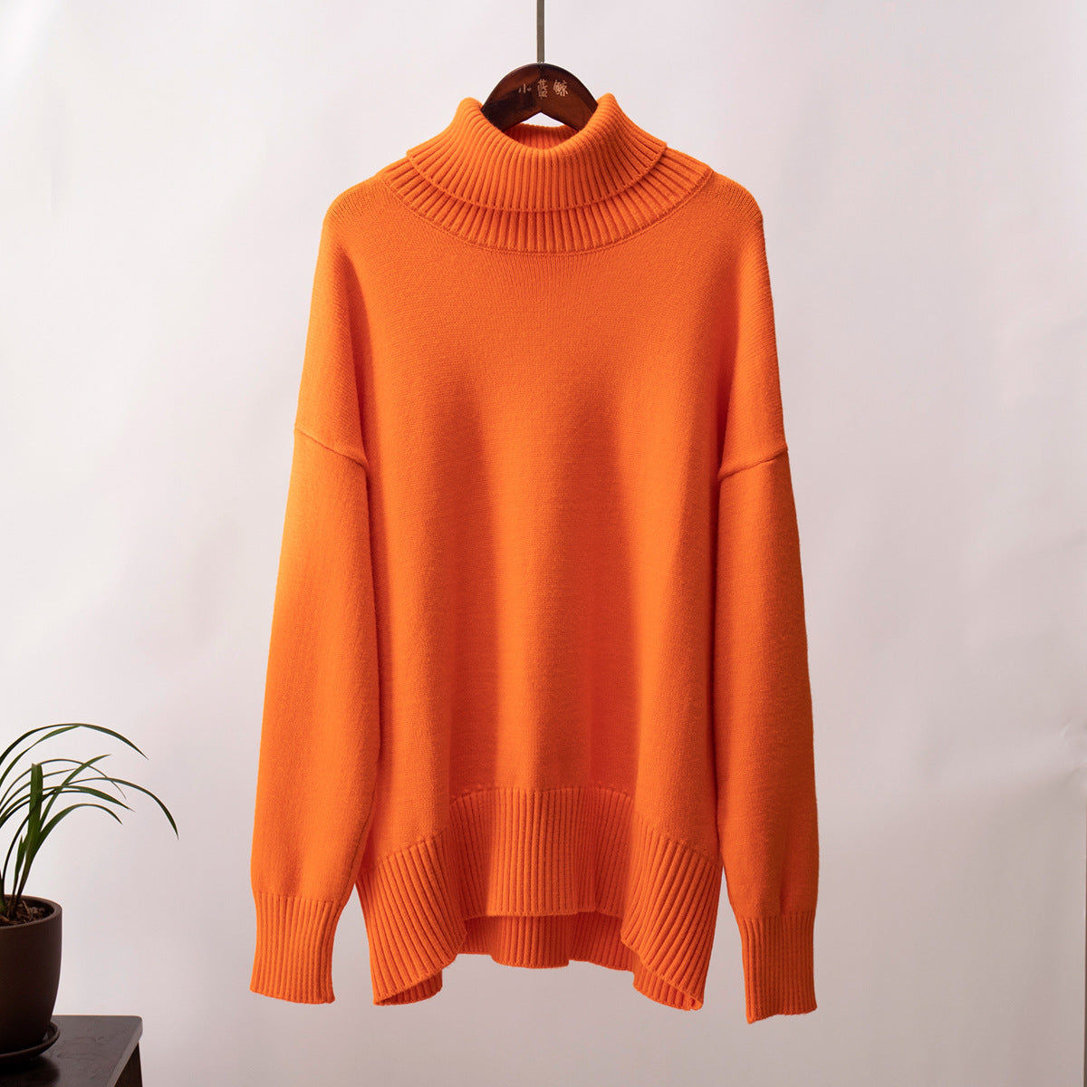 Burnt orange turtleneck sweater, wooden hanger, cozy knit texture, studio setting