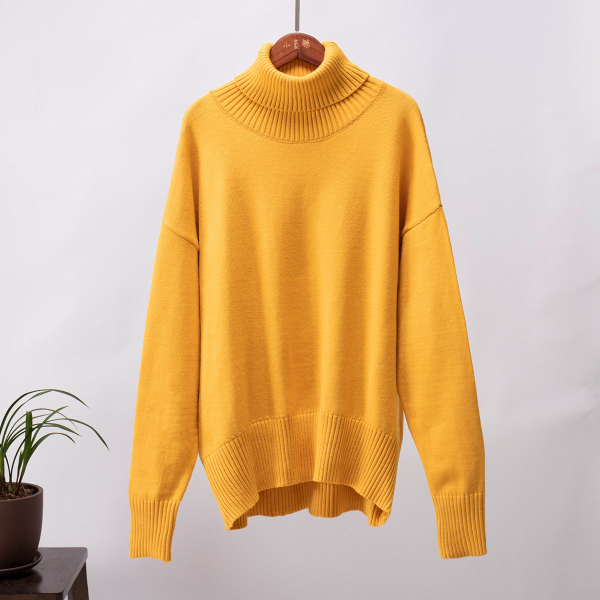 Mustard yellow turtleneck hanging, soft knit, relaxed fit, minimal background