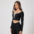 Black athletic two-piece set with white trim crop top, front tie closure and high-waisted compression leggings for workout and yoga wear
