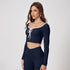 Navy blue workout set with scoop neck long sleeve crop top, decorative white tie front and matching high-waisted athletic leggings with ruched detail
