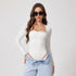 Model in white long-sleeve bodysuit with lace trim neckline, styled with light jeans, sunglasses, and wavy brown hair