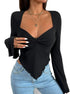 Detailed view of black sweetheart top with gathered front, white nails, and gold chain necklaces