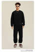 Model in black sweatsuit with white sunglasses, silver chain and brown/white Nike sneakers