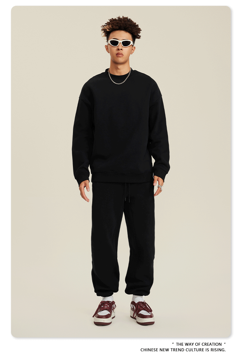Model in black sweatsuit with white sunglasses, silver chain and brown/white Nike sneakers