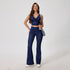Dark denim coordinated set featuring cropped tank top with ruched v-neck and flared pants, styled with white sneakers
