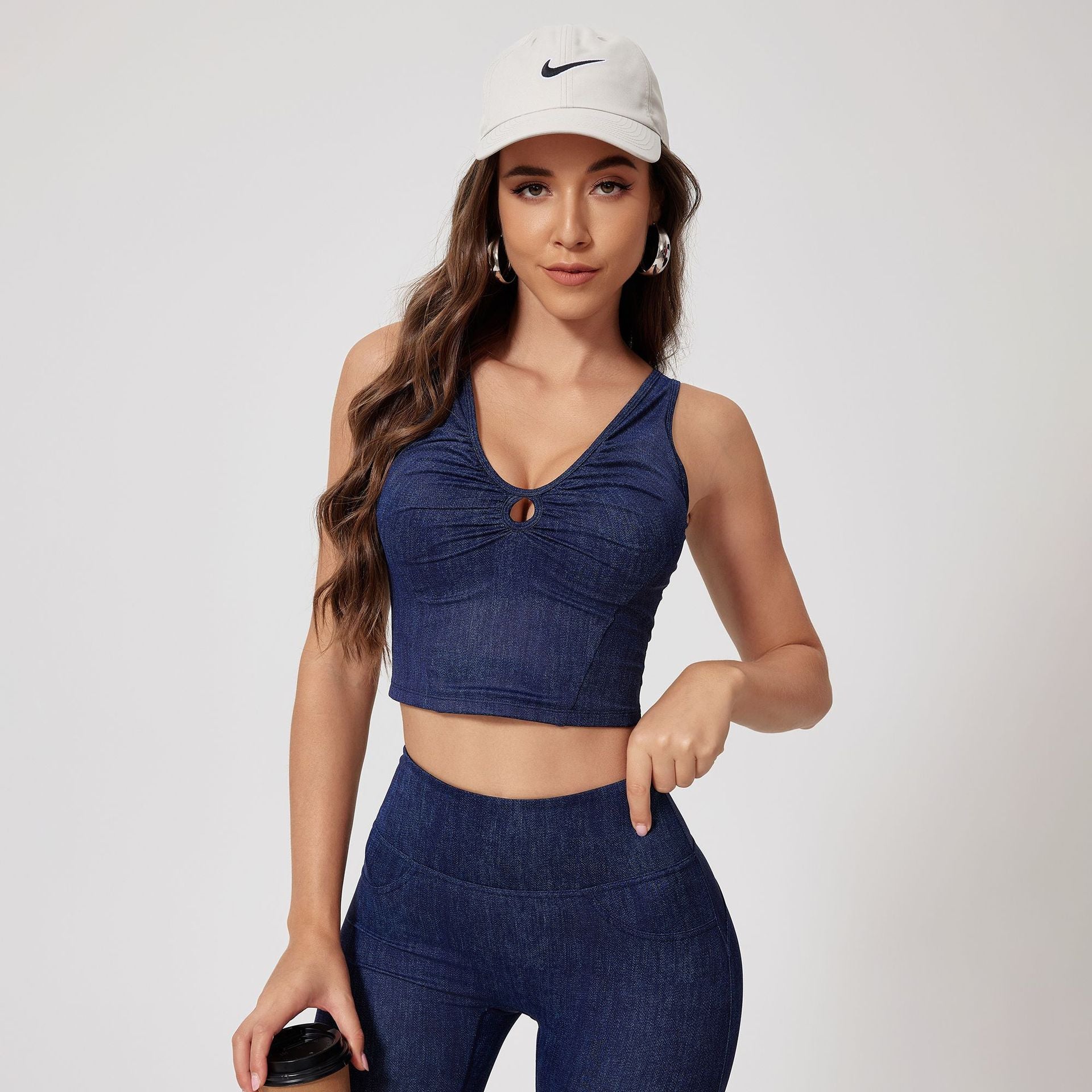 Navy denim crop top and high-waisted leggings set, top with keyhole detail, paired with white Nike cap
