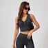 Dark denim athleisure set featuring ruched crop top and high-waisted leggings, accessorized with chain-strap bag