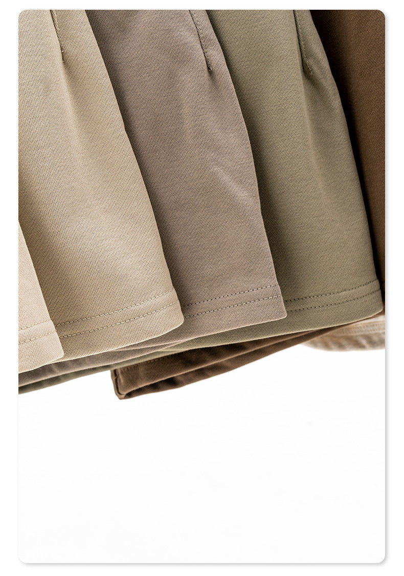 Close-up of the bottom hem and drawstring details of neutral-colored shorts with elastic waistbands