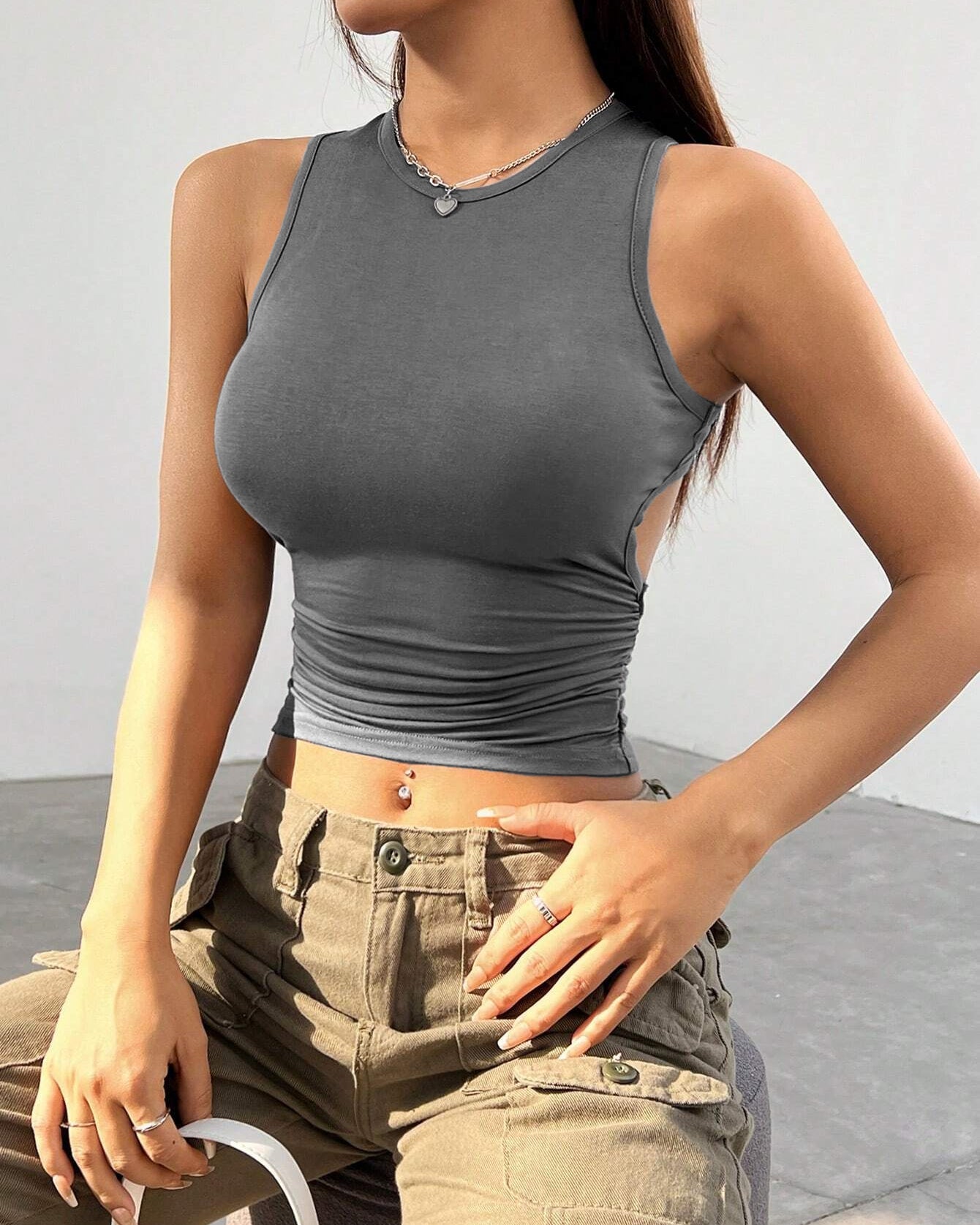 Gray sleeveless crop top with ruched waist, paired with khaki cargo pants, showcasing modern streetwear style