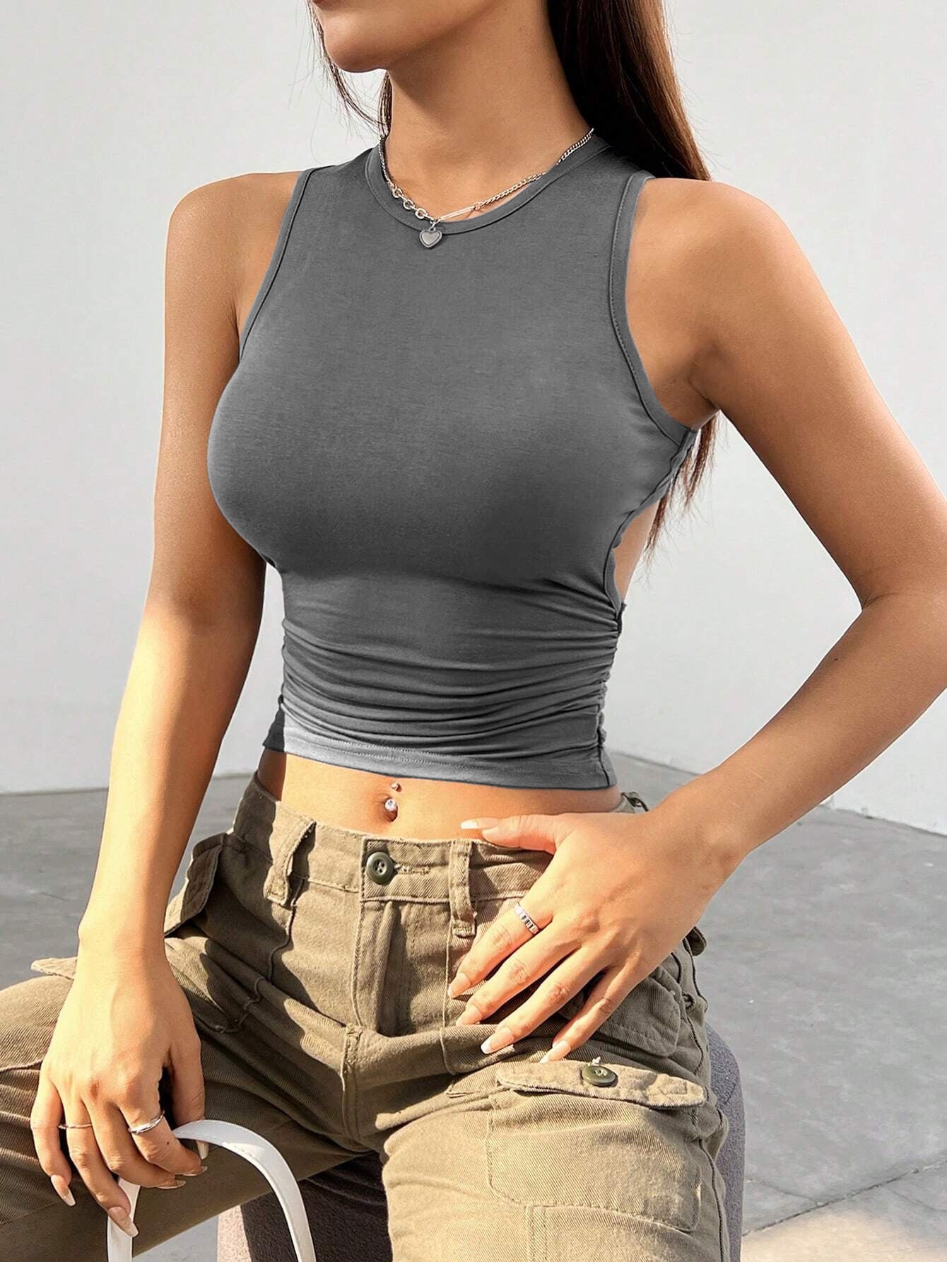 Gray sleeveless crop top with ruched waist, paired with khaki cargo pants, showcasing modern streetwear style