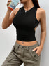 Black crop top with side cutout and navel piercing, styled with olive cargo pants and beverage accessory