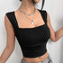 Detailed view of black square neck crop top showing ruched design and silver chain accessories