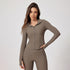 Woman in taupe colored activewear set with zip-front jacket, hooded collar and matching fitted leggings