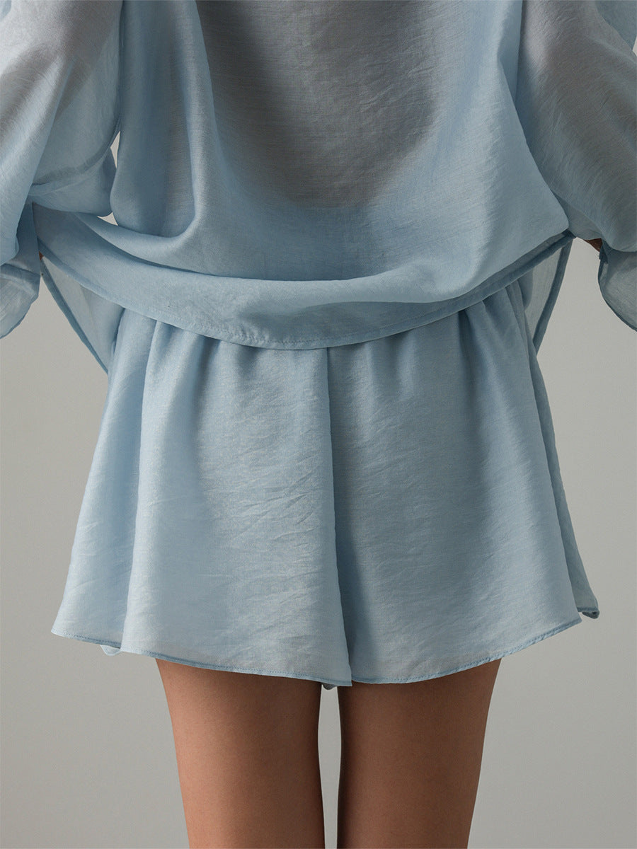 Light blue outfit with a skirt and long sleeves on a neutral background