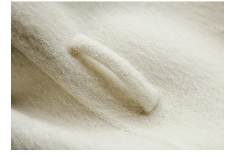 Macro texture shot of cream wool coating fabric showing fiber detail
