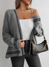 Gray cable knit cardigan with black trim, styled with white top and black leather bag, showcasing versatile layering
