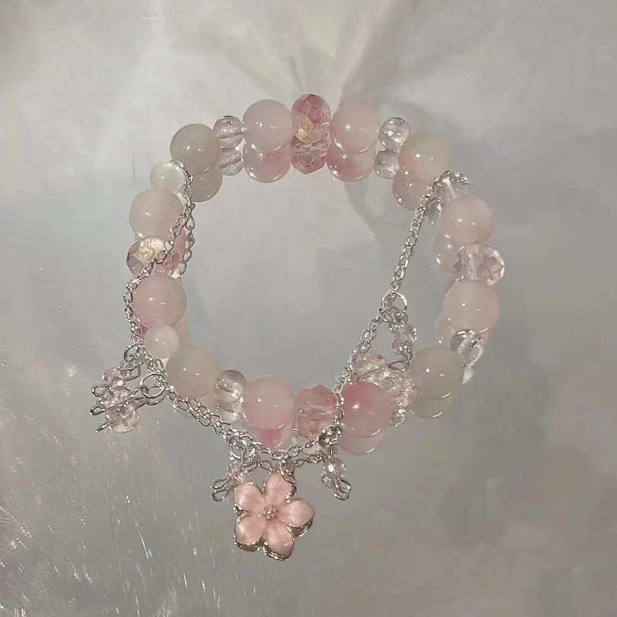 Rose quartz bracelet with silver cherry blossom charm and delicate chain accents