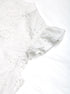 Ruffled sleeve detail of the white lace blouse, showcasing feminine and airy fabric texture.