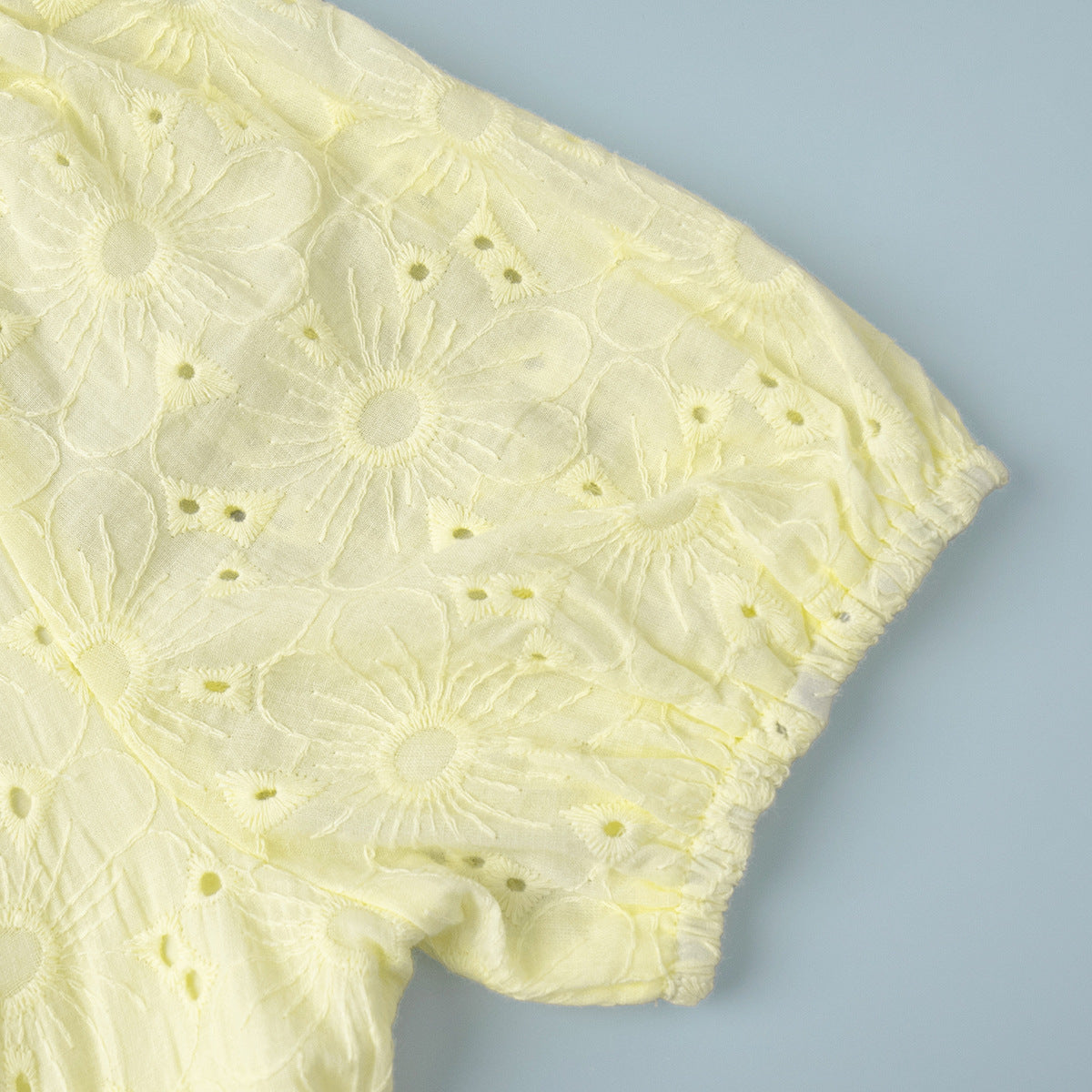 Yellow lace fabric on a light blue background