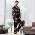 Black silk men's pajama set with golden dragon print, showcasing traditional loungewear style with all-over pattern
