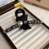 A black hair claw clip featuring a satin bow, dark pearls, and crystal embellishments for a chic, sophisticated look.