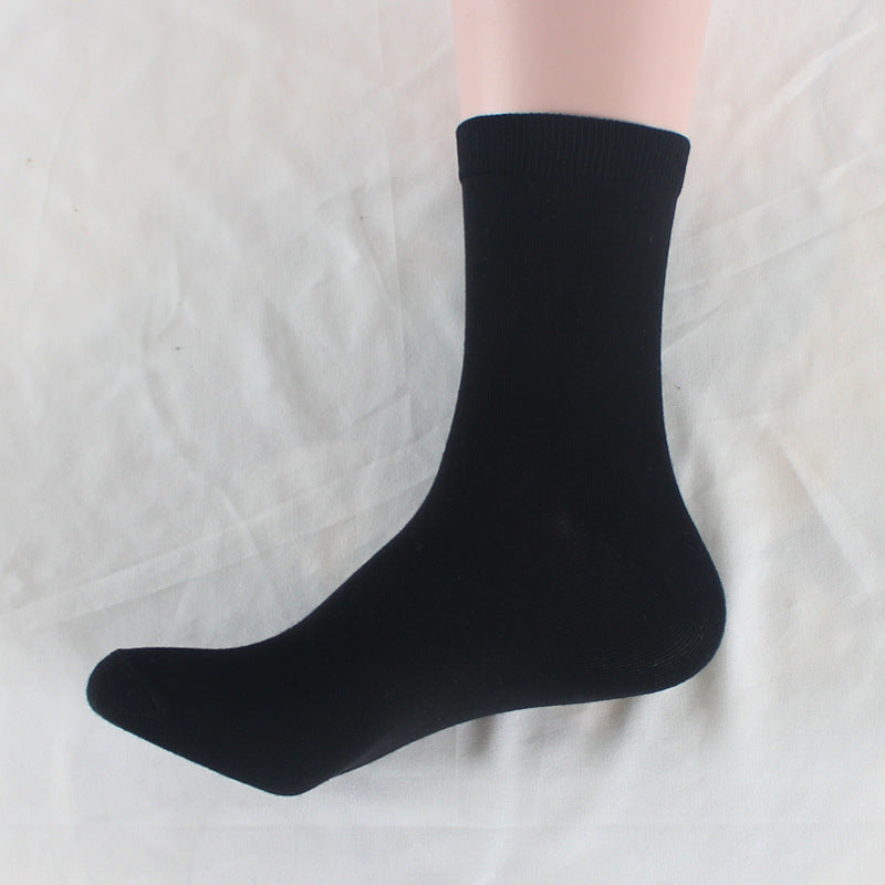 Single black cotton crew sock positioned on white surface, showcasing basic sock design