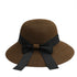 Brown straw sun hat with a black ribbon bow, offering a chic and sophisticated sun protection style.