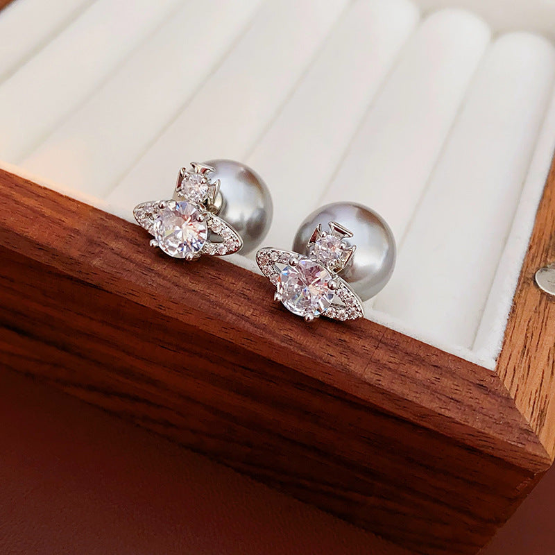Detailed view of silver crystal orbit earrings with pearl back