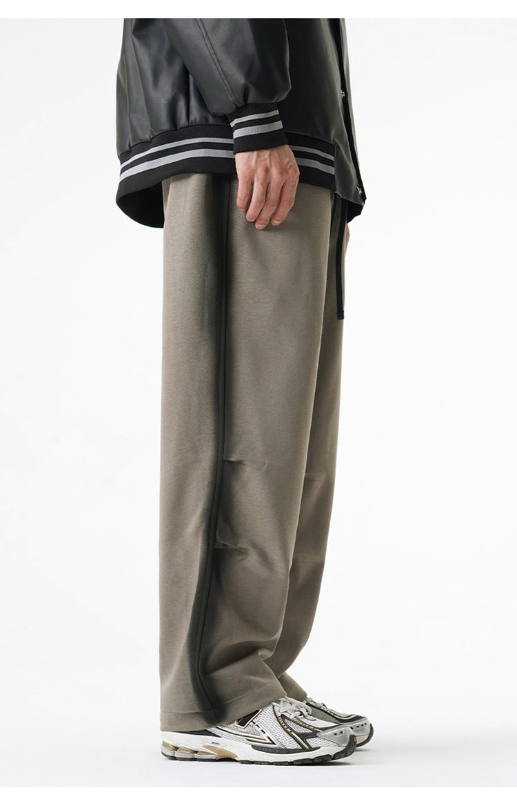 Side view of gray wide-leg pants featuring a subtle black stripe along the seams