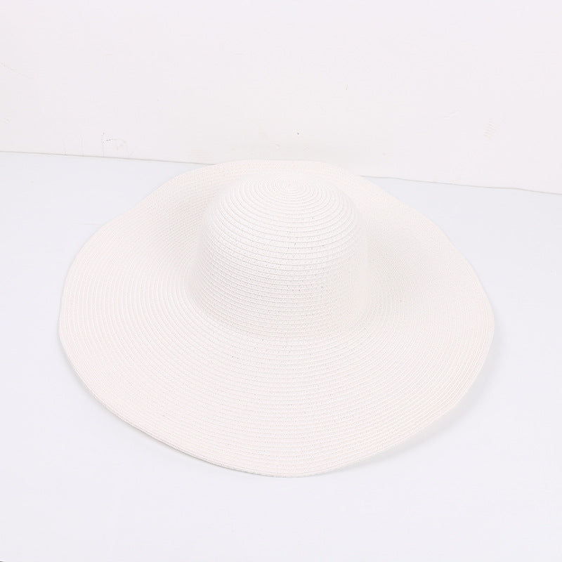White wide-brimmed sun hat with a classic floppy design, displayed on a white surface.