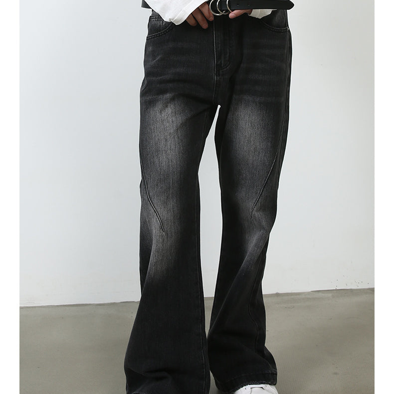 A model adjusting black leather belt with silver buckle, wearing black wide-leg jeans and white sneakers against minimalist backdrop