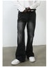 A model adjusting black leather belt with silver buckle, wearing black wide-leg jeans and white sneakers against minimalist backdrop