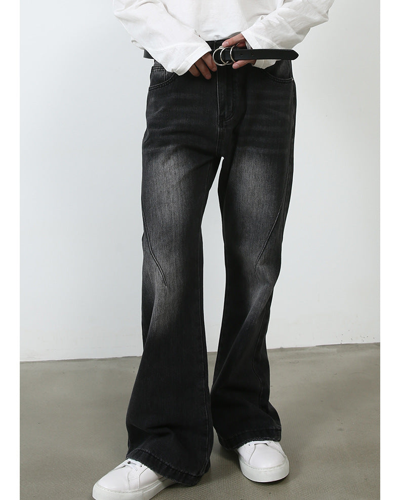 A model adjusting black leather belt with silver buckle, wearing black wide-leg jeans and white sneakers against minimalist backdrop
