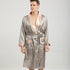 Man in champagne and taupe geometric print robe. Close-up shows contrast satin lapels and patch pockets with coordinating trim against neutral background